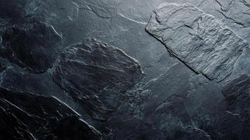 Monochrome stone background with rough, textured surface. Dark gray and black rocks create an abstract pattern, ideal for graphic design. photo