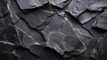 Abstract texture of dark grey slate stone tiles, creating a rugged and natural wall covering pattern. Solid and stylish backdrop. photo