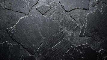 Detailed texture of dark, rough slate rock with visible layering and natural patterns, perfect for backgrounds and architectural elements. photo