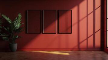 A plant sits beside three empty picture frames, casting a shadow pattern on a rust-colored wall in a room with hardwood floors. photo