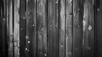 A black and white photograph of a weathered wood fence, its texture evoking rustic charm and vintage appeal with subtle color variations. photo