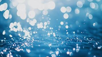 Sunlight sparkles on blue water, creating a beautiful bokeh effect. The gentle waves and shimmering light add to the serene scene. photo
