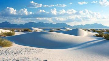 Serene landscape showcasing white gypsum dunes against a backdrop of mountains and a cloudy sky, capturing nature's tranquil beauty. photo