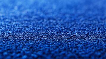 A deep textured blue surface sits under bright lighting, capturing the intricate details and patterns, making it an excellent choice for backgrounds or creative photography. photo