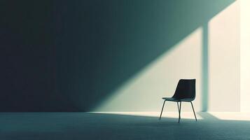 This minimalist image features a solitary black chair set in a dim room, creating a poignant atmosphere defined by shadows and light that symbolizes solitude and reflection. photo