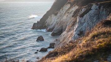 Coastal cliffs meet the ocean in a display of natural beauty, with waves crashing and rocks adding drama to the coastal scene. photo