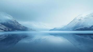 A serene landscape featuring snow-covered mountains reflected in a calm, misty lake, creating a peaceful and ethereal ambiance. photo