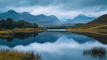 Scenic vista of tranquil lake mirroring mountainous landscape under a cloudy sky, capturing nature's serene beauty and reflective ambiance. photo