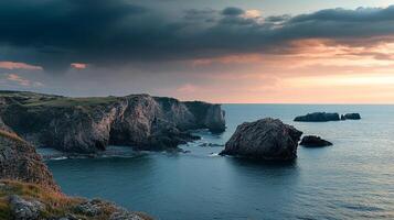 Coastal cliffs meet the ocean under a dramatic sky, showcasing nature's raw beauty at sunset. Serene seascape with rocky formations. photo