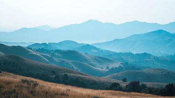 Rolling hills cascade into the horizon, painted with shades of blue and earth tones, creating a serene and peaceful landscape. photo