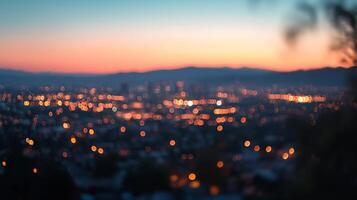A bokeh cityscape at dusk, showcasing blurred lights against a backdrop of mountains and a gradient sky. A serene urban view. photo