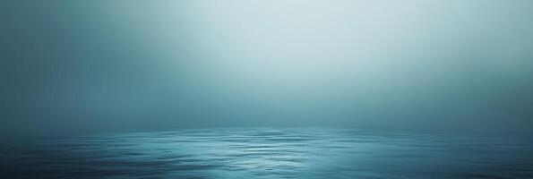 Tranquil water surface with a gradient light blue backdrop evoking serenity. Minimalist composition captures a sense of peace and depth. photo