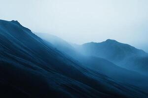 Misty mountains in a cool blue hue, showcasing layered landscapes and atmospheric depth. An image of serene natural beauty. photo