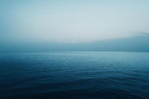 A serene seascape captures the tranquil boundary where the deep blue ocean merges seamlessly with the soft gradient of the sky in calm elegance. photo