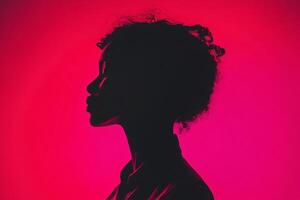 Silhouette of a person against a red backdrop, highlighted by soft lighting, evoking mystery and elegance. Timeless minimalist portrait. photo