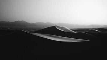 Monochromatic desert landscape with dunes shaped by wind and distant mountain peaks, rendered in stark black and white. Serene. Minimalist. photo