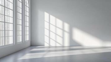 Sunlight streaming through arched windows illuminates a bright, minimalist room, casting geometric patterns on the walls and floor. photo