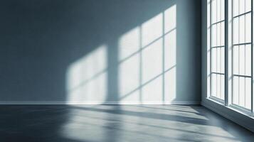Sunlight streaming through a window casts geometric shadows across the wall and floor of an empty room, creating a peaceful atmosphere. photo