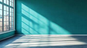 Sunlit corner showcasing a room with an aqua-colored wall, casting shadows from a large window, creating a serene, bright interior space. photo