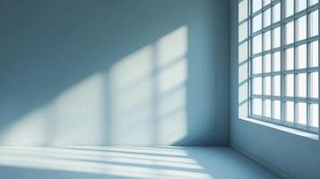 Sunlight streams through a multi-pane window, casting geometric shadows on the pale blue wall and floor of a bright, empty room. photo