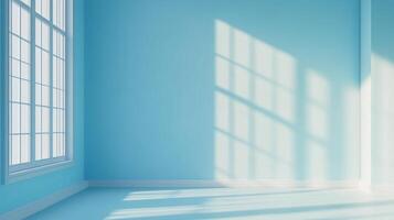 A bright, naturally lit empty room with a large window casting light patterns on the blue wall. The room is minimal and serene. photo