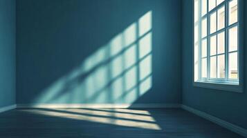 Sunlight streams through a window casting patterns on a blue wall. The light creates a calming and modern atmosphere in an empty room. photo