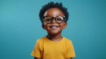 A young child wearing glasses, exuding joy with a bright, infectious smile against a solid blue backdrop, capturing a moment of pure happiness. photo