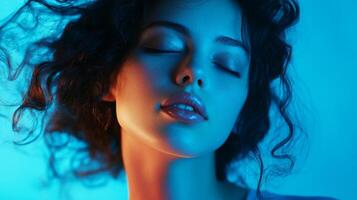 Ethereal beauty. A dreamy portrait of a model with closed eyes and soft, glowing skin bathed in surreal blue and orange lighting. photo