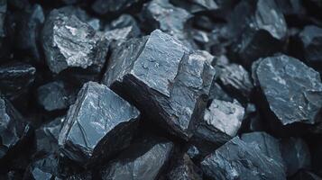 A close up shot displaying the intricate textures and angular shapes of dark rock fragments, emphasizing their rough surfaces. photo