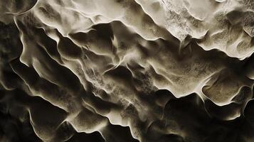 Aerial shot of light and dark sand patterns creating rippling formations in the desert with contrast and texture visible. photo