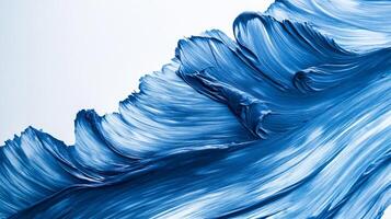 A wave of deep blue paint sweeps across the canvas, texture and movement vividly captured in this abstract composition. photo