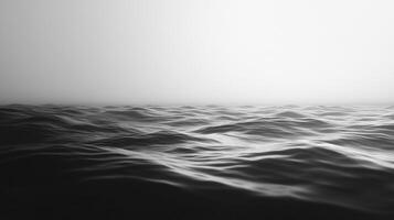 Monochromatic ocean view with gentle waves, blending into a hazy horizon for a serene and minimalist seascape. photo