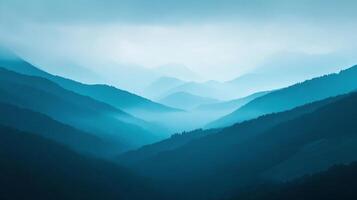 Serene mountain range shrouded in mist, showcasing shades of blue, depth and tranquility, creating a picturesque, calming scene. photo