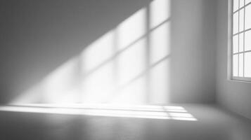 Bright sunshine streaming through a window in a simple, clean empty room, creating a beautiful display of light and shadow. photo