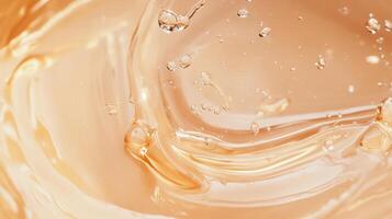 Close-up of translucent, light orange gel with trapped air bubbles and swirling patterns. The gel's texture appears smooth and slightly viscous. photo