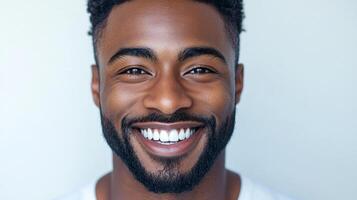 Close-up shot of a happy, handsome man with perfect teeth, smiling against a bright, clean backdrop with a joyful expression. photo