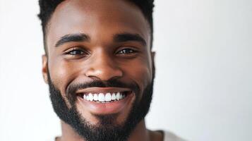 Smiling face of a young man with a beard. His joyful expression is illuminated by the bright studio lighting. A portrait of happiness. photo