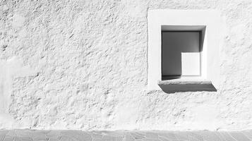 Monochromatic image of textured wall, with a white window inset, offering a study in light, shadow, and architectural details. photo