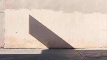 A stark shadow dramatically slices across a textured beige wall, juxtaposed with a concrete sidewalk, creating a study in contrast and light. photo