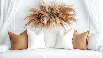 A white couch with pillows and a large pampas grass decoration photo