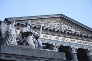 A statue of a woman holding a book and a statue of an angel photo