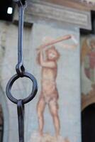 A large metal chain with a painting of a man on it photo