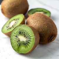 Fresh kiwi fruit with its fuzzy outer skin and vibrant green interior, sliced to reveal the refreshing pulp and black seeds inside photo