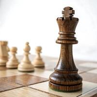 wooden chess king piece on a chessboard with pawns in the background, highlighting the intricate design and texture photo