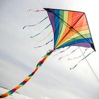 Fun and artistic kite with a kaleidoscope of patterns and rainbow colored ribbons, capturing the essence of flying in the open air photo
