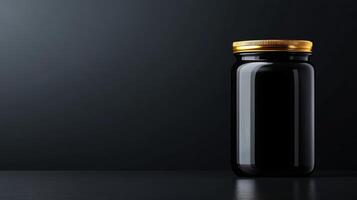 Jar of black substance with golden lid on dark surface photo