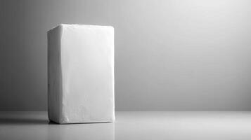 White block standing alone on a minimalist surface in midday light photo
