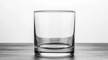 Empty glass on wooden table with plain background photo