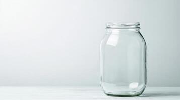 Clear glass jar resting on a white wooden table in soft light photo