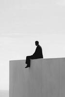 Man sitting on a high ledge, contemplating the vast horizon photo